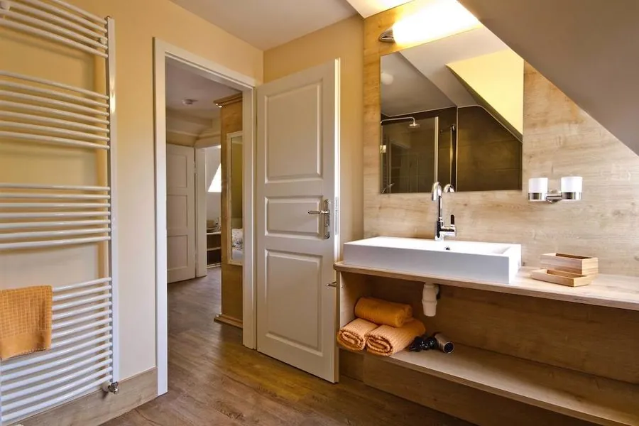Badezimmer mit Waschtisch aus Holz und Handtuchwärmer