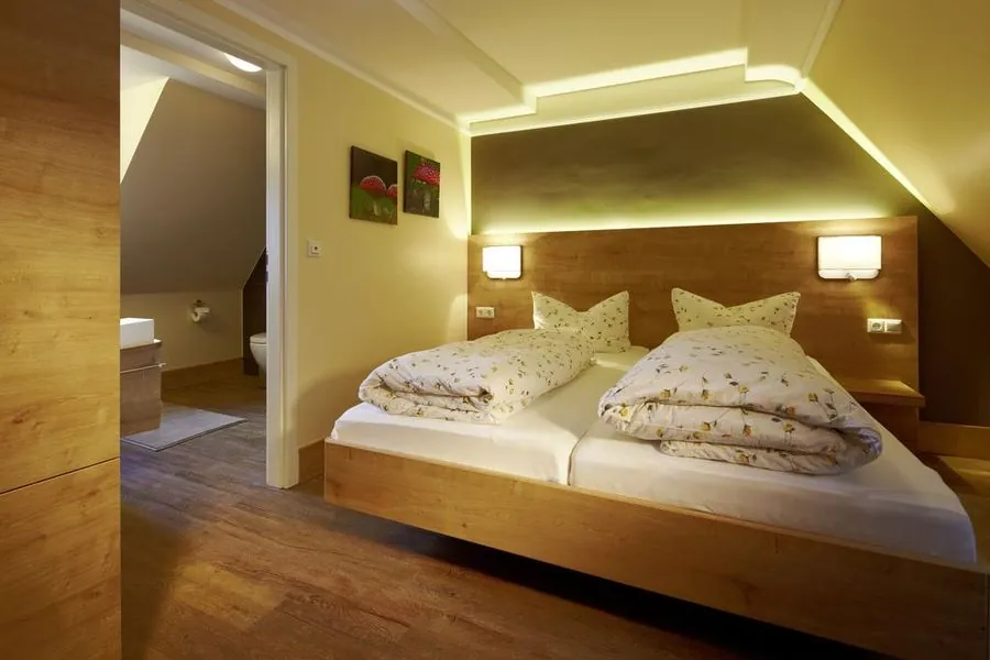 Zimmer-Ausführung unter der Dachschräge mit Blick ins Badezimmer