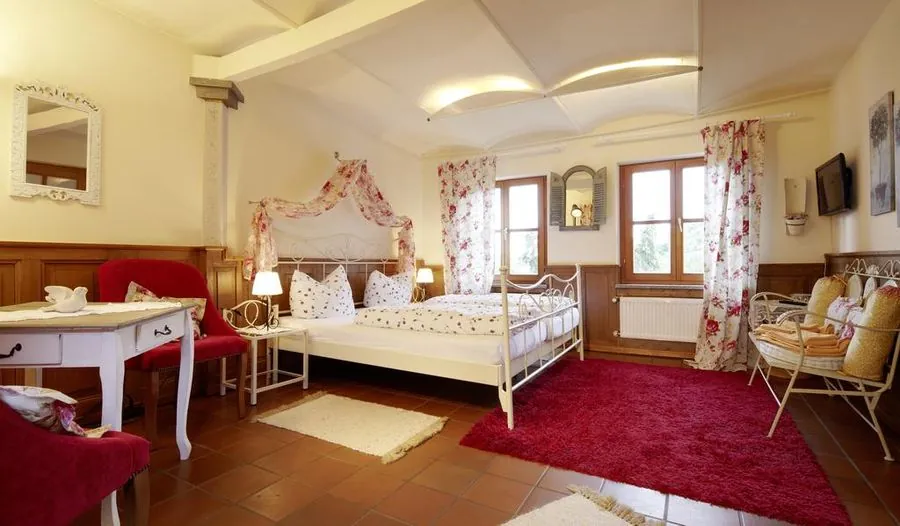 Zimmer-Ausführung im Landhausstil mit Metallbett und rotem Teppich