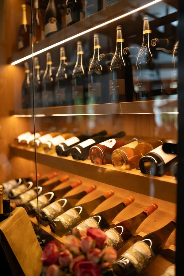 Liegende Flaschen im beleuchteten Weinregal