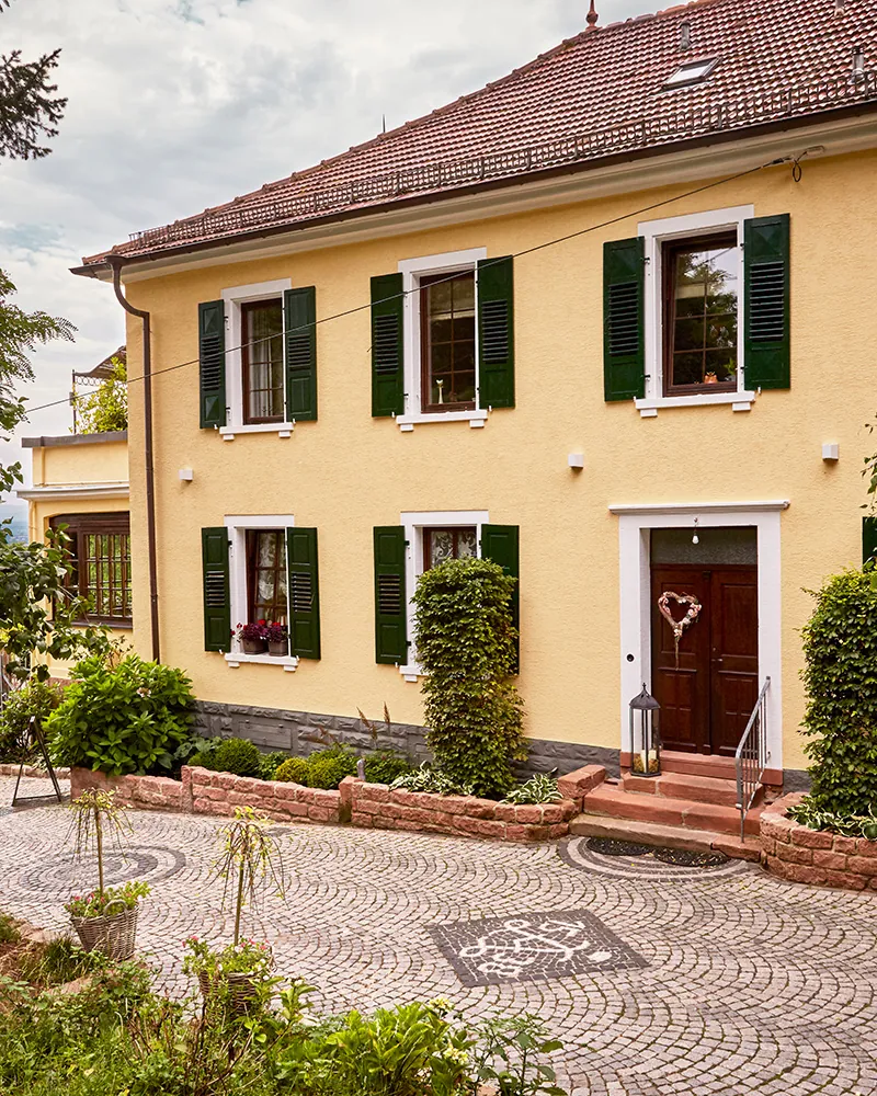 Das Gutshaus des Weinguts Sankt Annaberg mit Reben davor