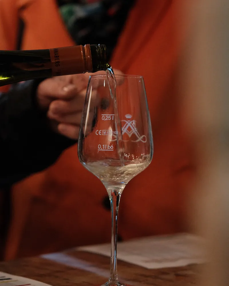 Zwei Hände mit Rieslinggläsern bei einer Weinprobe