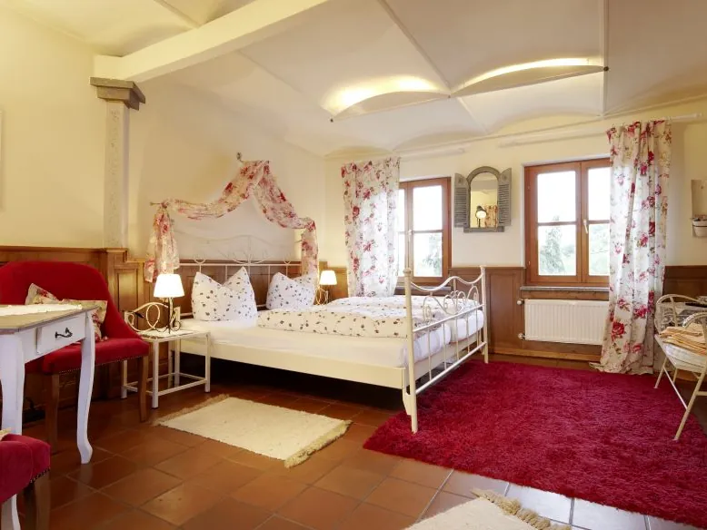 Helles Zimmer im Gutshotel mit Doppelbett und Sitzecke